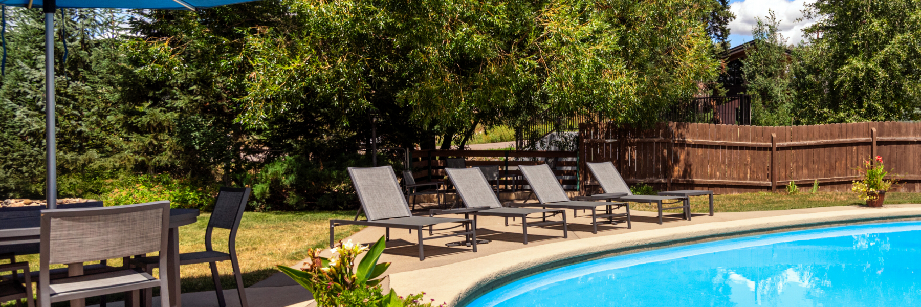 Nordic Lodge's outdoor pool in the summer time with chairs next to it